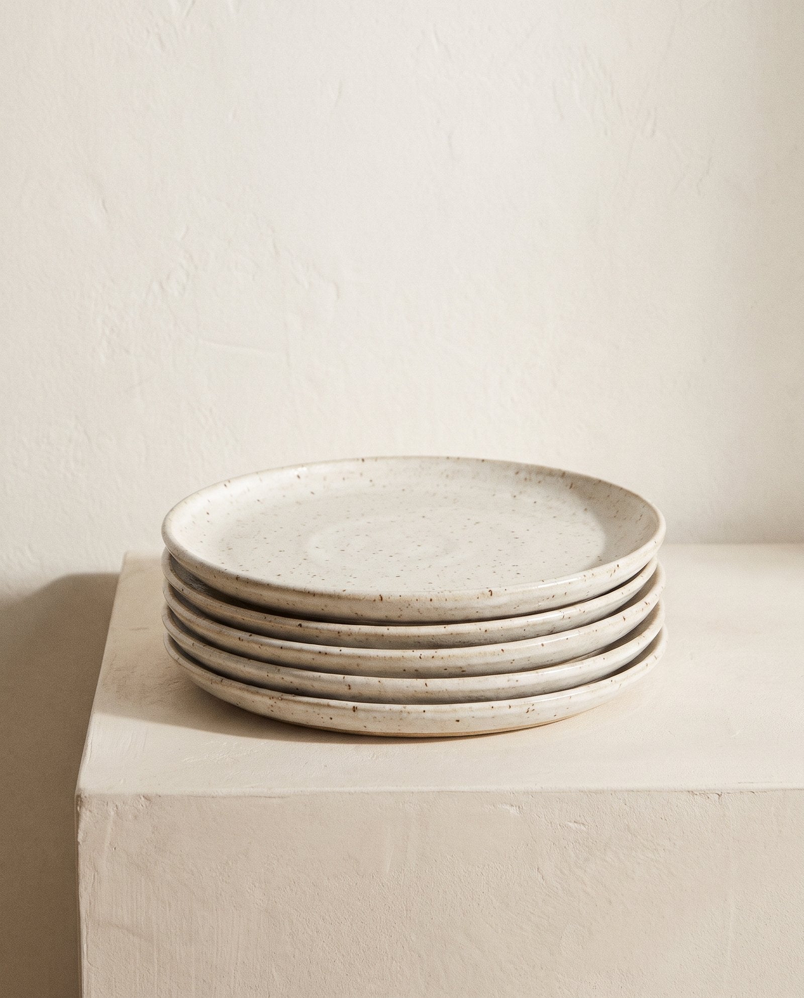 Stoneware plates on a plaster surface