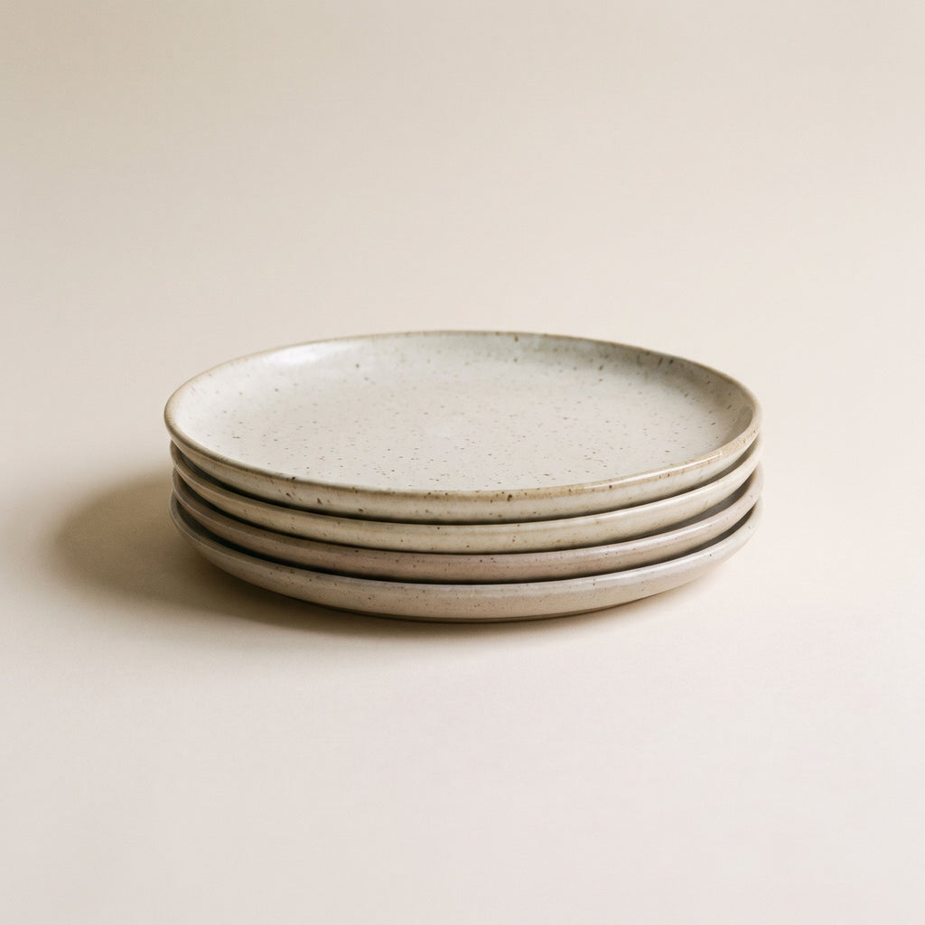 Stack of four speckled stoneware dinner plates